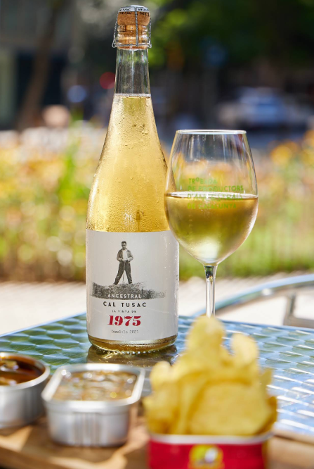 Botella y copa de vino natural servidas en la terraza de L’Estel